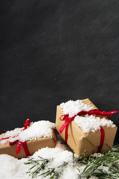 Χριστουγεννιάτικα δώρα στο χιόνι κατά ένα μαυροπίνακα — Φωτογραφία Αρχείου