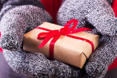 Kırmızı kurdele ile sarılmış bir hediye holding açık eller