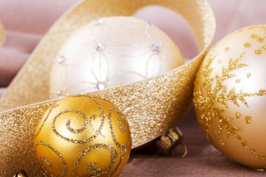 Kumaş arka plan üzerinde şenlikli altın Noel süsleri