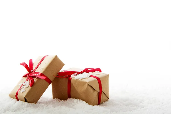 Різдвяні подарунки в коричневому папері з червоною стрічкою — стокове фото