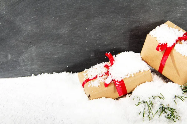 Різдвяні подарунки в снігу на дошці — стокове фото