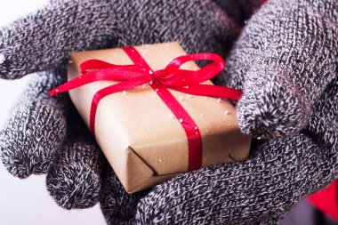 Kırmızı kurdele ile sarılmış bir hediye holding açık eller