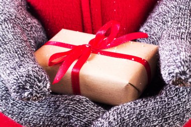 Kırmızı kurdele ile sarılmış bir hediye holding açık eller