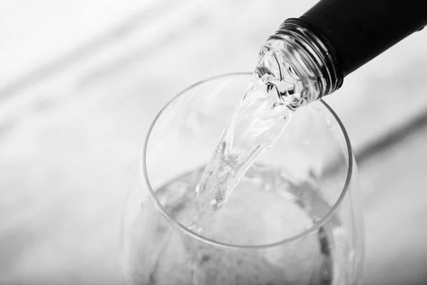 Skleničku bílého vína sypu z láhve — Stock fotografie