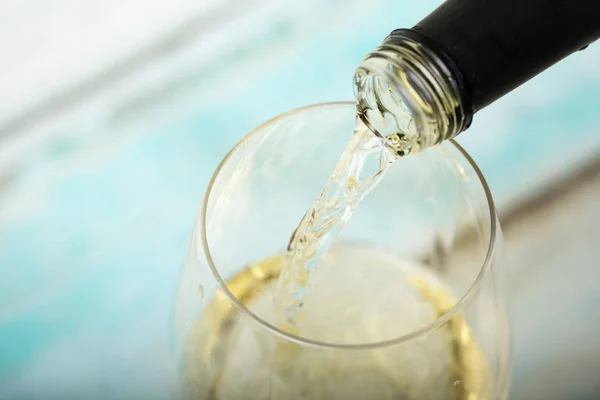 Glass of white wine being poured from bottle — Stock Photo, Image