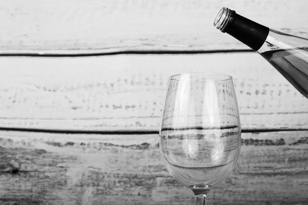 Skleničku bílého vína sypu z láhve — Stock fotografie