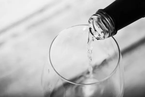 Verre de vin blanc versé de bouteille — Photo