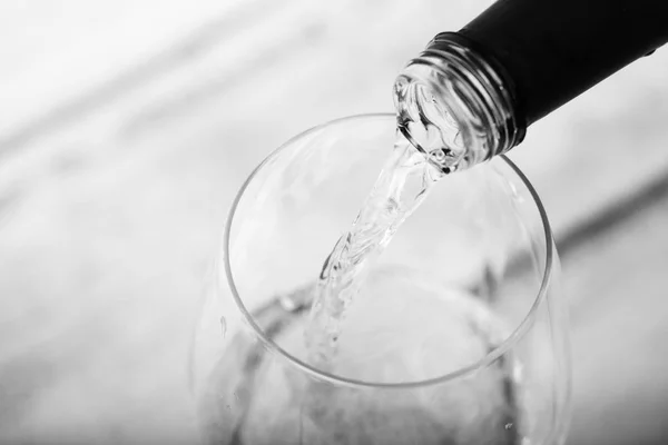 Из бутылки наливают стакан белого вина — стоковое фото