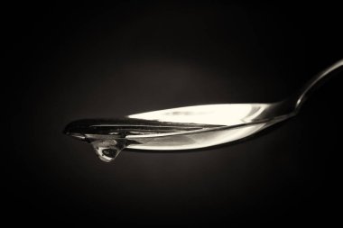 Tatlım kaşık karanlık bir arka plan karşı dökme