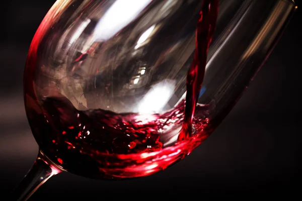 Glass of full bodied red wine being poured — Stock Photo, Image