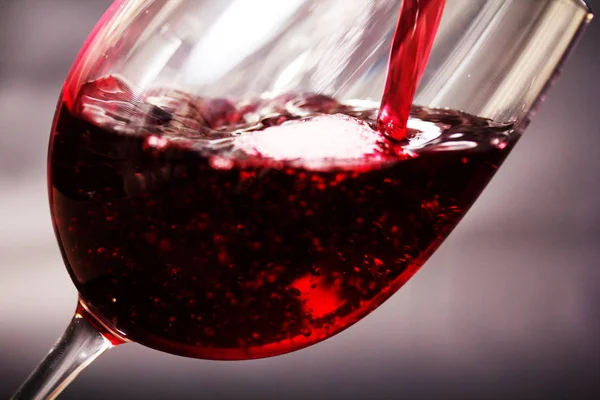 Glass of full bodied red wine being poured — Stock Photo, Image