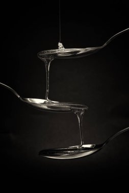 Tatlım kaşık karanlık bir arka plan karşı dökme