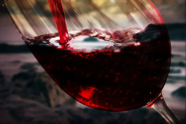 Ποτήρι πλήρη αμαξωτού κόκκινο κρασί που χύνεται — Φωτογραφία Αρχείου