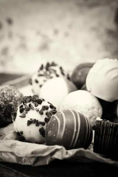 Seleção de deliciosos chocolates em um fundo rústico — Fotografia de Stock