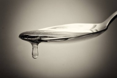 Tatlım kaşık hafif bir arka plan karşı dökme