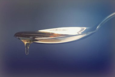 Tatlım kaşık karanlık bir arka plan karşı dökme