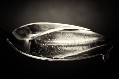 Tatlım kaşık karanlık bir arka plan karşı dökme