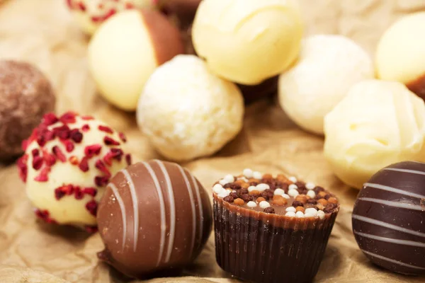 Rustik bir arka plan üzerinde lezzetli çikolata seçimi — Stok fotoğraf