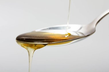 Tatlım kaşık hafif bir arka plan karşı dökme