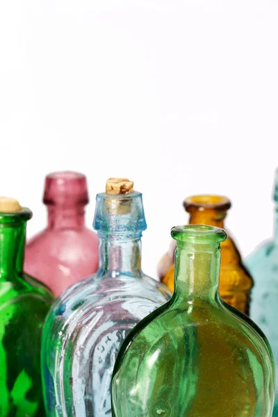 Vecchie bottiglie colorate contro uno sfondo bianco — Foto Stock