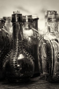 Rustik bir arka plan üzerinde renkli cam şişe