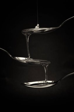 Tatlım kaşık karanlık bir arka plan karşı dökme