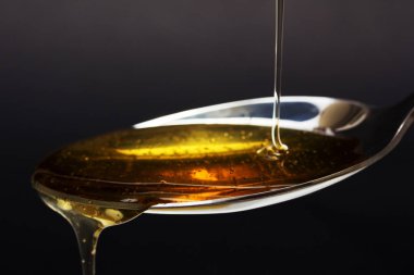 Tatlım kaşık karanlık bir arka plan karşı dökme