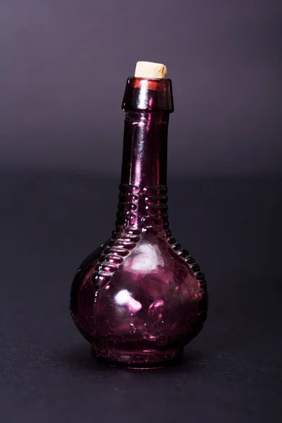 Viejas botellas de colores sobre un fondo oscuro — Foto de Stock