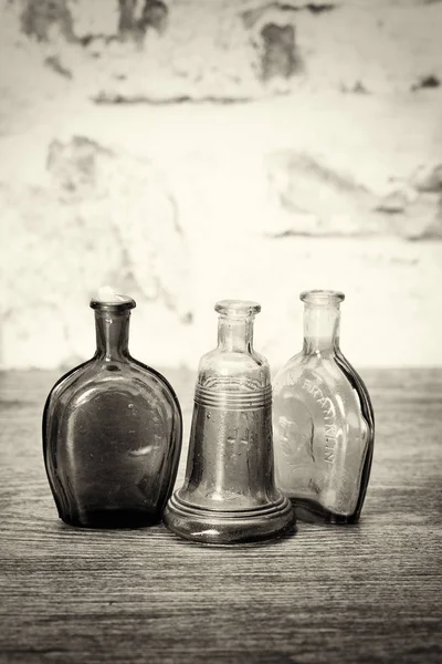 Coloured glass bottles on a rustic background — Stock Photo, Image