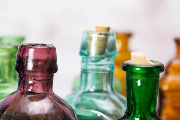 Coloured glass bottles on a rustic background — Stock Photo, Image