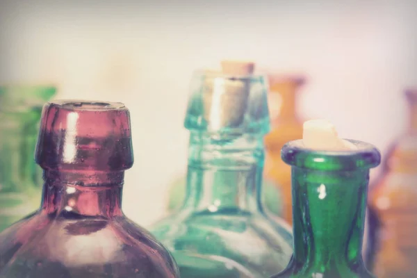 Barevné skleněné láhve na rustikální pozadí — Stock fotografie
