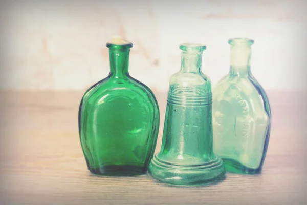 Gekleurde glazen flessen op een rustieke achtergrond — Stockfoto