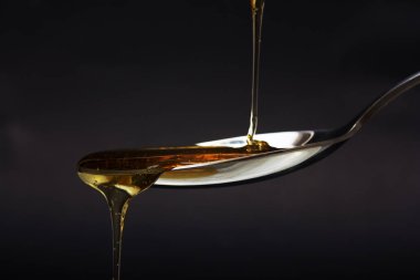 Tatlım kaşık karanlık bir arka plan karşı dökme