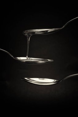 Tatlım kaşık karanlık bir arka plan karşı dökme