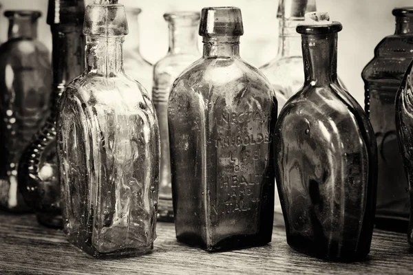 Kolorowych szklanych butelek na tle rustykalnym — Zdjęcie stockowe