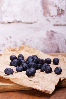 Rustik kahverengi kağıt arka plan üzerinde taze yaban mersini