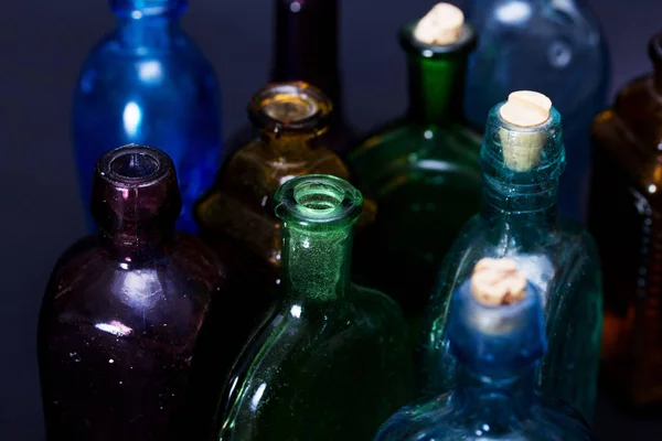 Viejas botellas de colores sobre un fondo oscuro —  Fotos de Stock