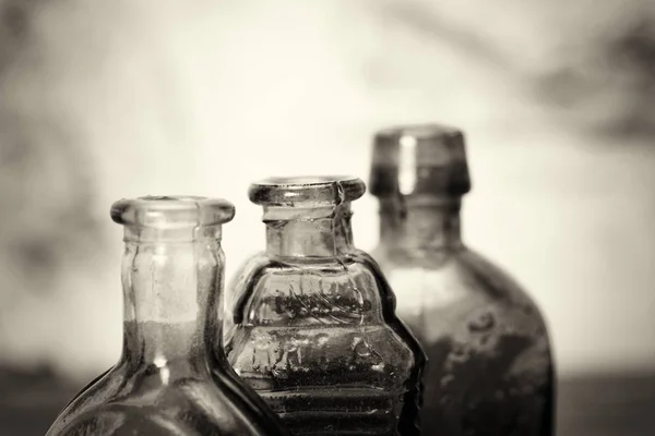 Bouteilles en verre coloré sur fond rustique — Photo