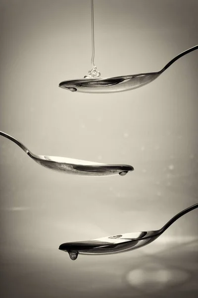 Медовий налив з ложки на світлий фон — стокове фото