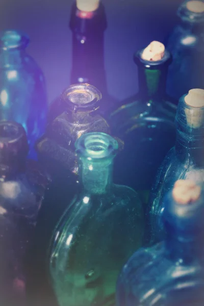 Alte bunte Flaschen vor dunklem Hintergrund — Stockfoto