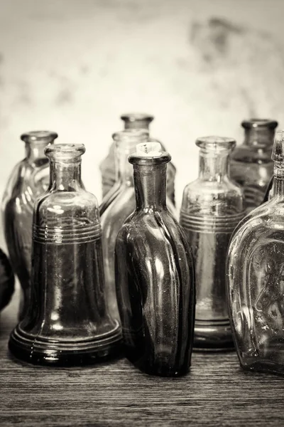 Barevné skleněné láhve na rustikální pozadí — Stock fotografie