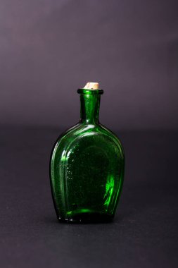 Karanlık bir arka plan karşı eski renkli şişe