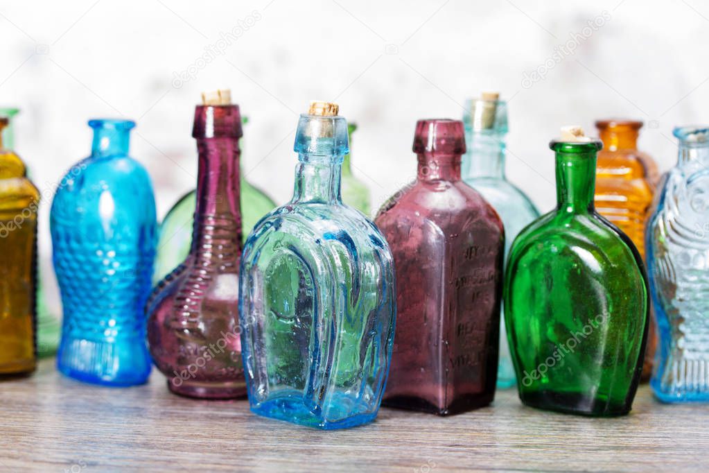 Coloured glass bottles on a rustic background