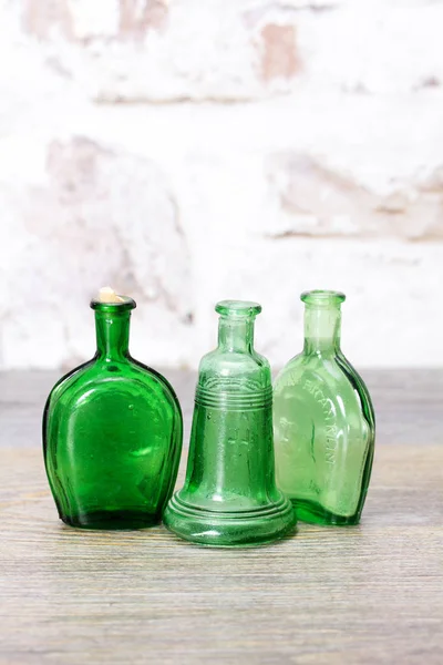 Bottiglie di vetro colorato su sfondo rustico Foto Stock Royalty Free
