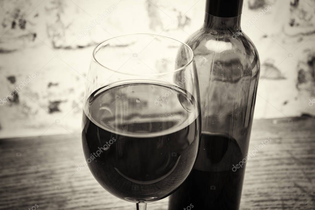 Bottle of red wine with glass ready to pour