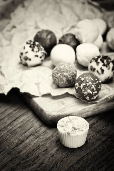 Seleção de deliciosos chocolates em um fundo rústico — Fotografia de Stock