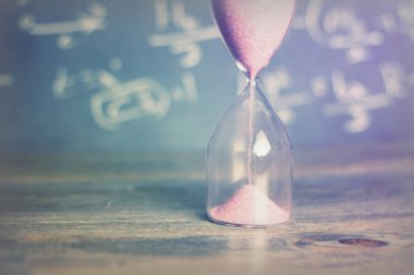 Bir kara tahta arka plan ile ahşap üzerine kum saati