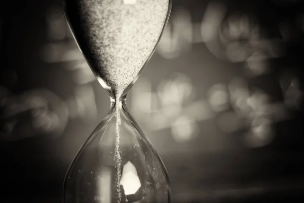 Hourglass on wood with a blackboard background — Stock Photo, Image