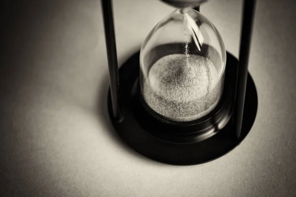 Reloj de arena negro grande sobre un fondo azul —  Fotos de Stock