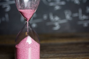 Bir kara tahta arka plan ile ahşap üzerine kum saati